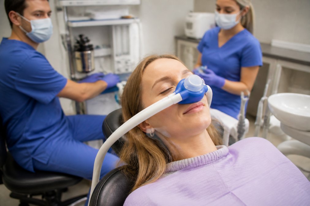 Patient receiving nitrous oxide during sedation dentistry options in a modern, bright dental clinic.